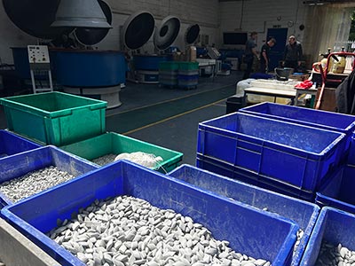 two engineers working on a vibratory finishing machine