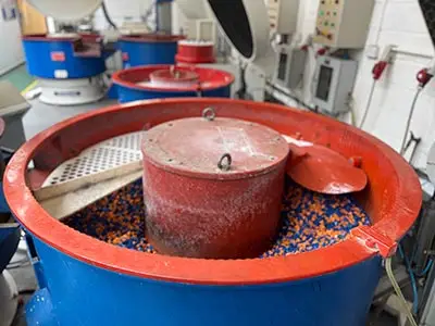 The Oxymoron of Hand Deburring and Polishing a row of vibratory finishing machines
